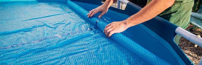 Die Abdeckplane eines Pools wird abgenommen.