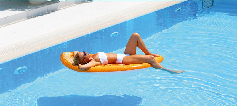 Eine Frau liegt auf einer Luftmatratze im Pool 